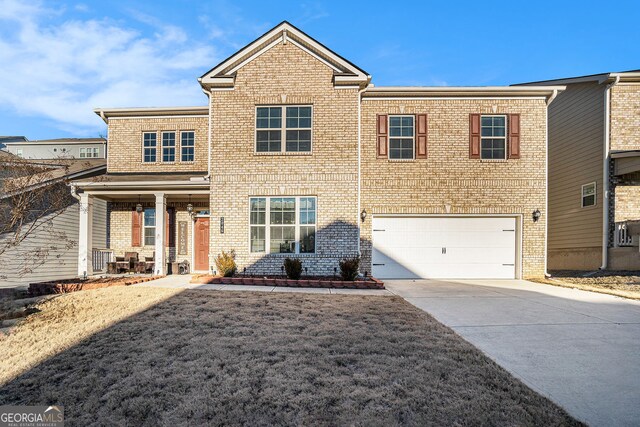 view of front of property featuring a front lawn, brick siding, concrete driveway, and an attached garage