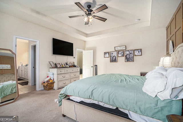 bedroom featuring light colored carpet, a raised ceiling, and ceiling fan