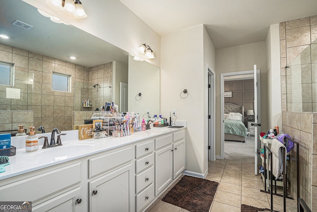 bathroom with tile patterned floors, vanity, and a tile shower