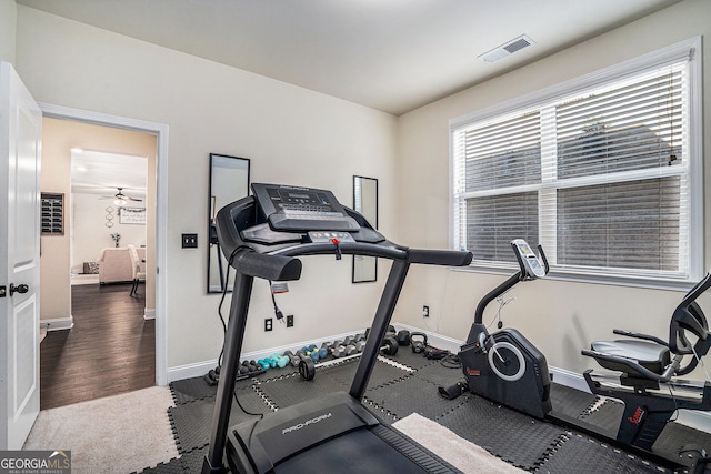 exercise area with wood finished floors, baseboards, and visible vents