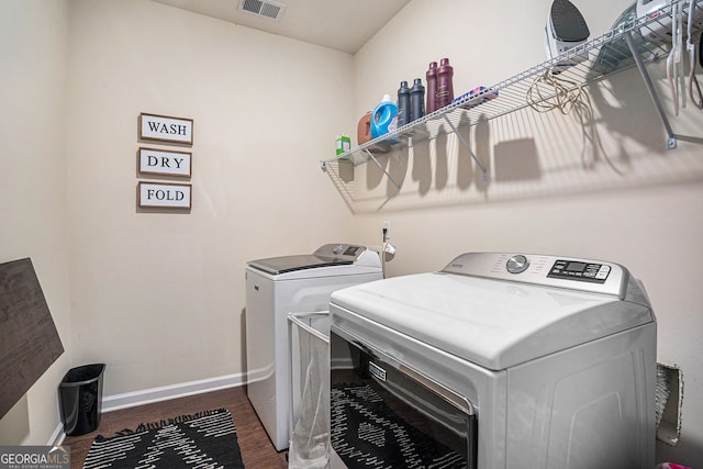 laundry room featuring washer and dryer and dark hardwood / wood-style flooring