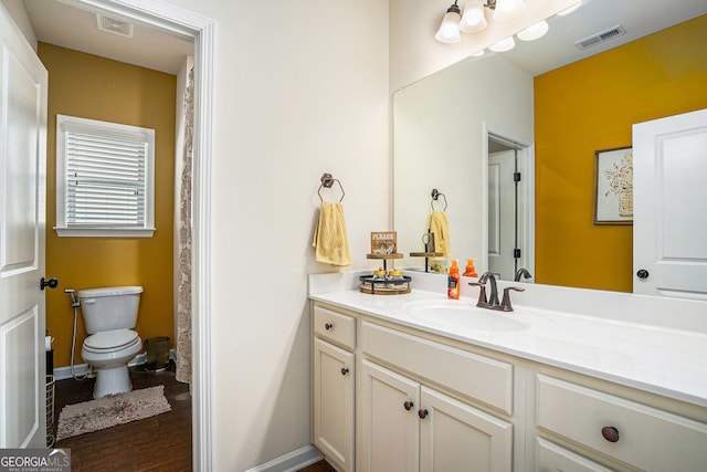 full bathroom with vanity, toilet, baseboards, and visible vents