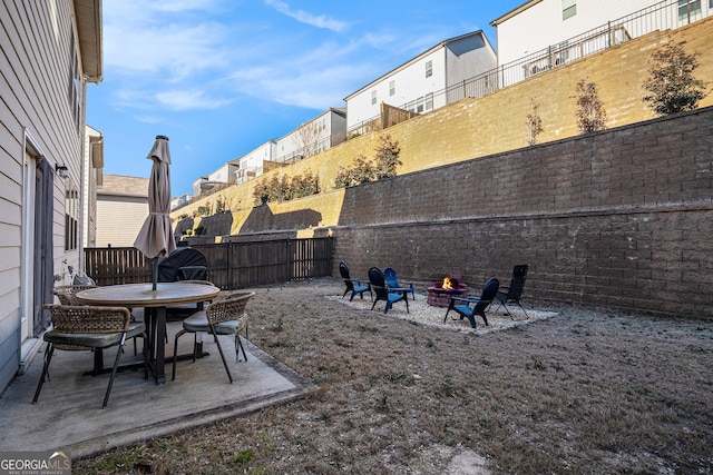 view of yard with a patio, fence, and an outdoor fire pit