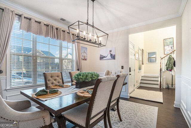 dining area featuring ornamental molding, dark wood-type flooring, and a chandelier