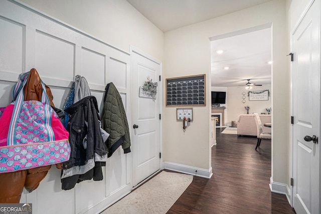 foyer entrance featuring baseboards, a lit fireplace, recessed lighting, dark wood-style floors, and a ceiling fan