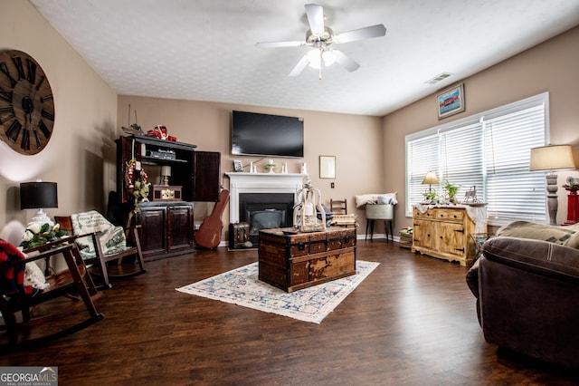 living room featuring ceiling fan and dark hardwood / wood-style flooring