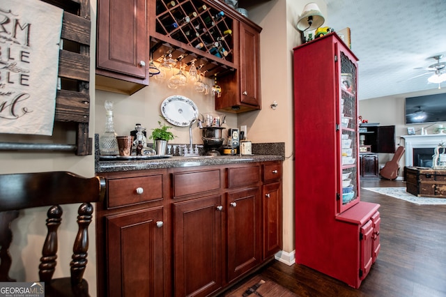 bar with ceiling fan and dark wood-type flooring