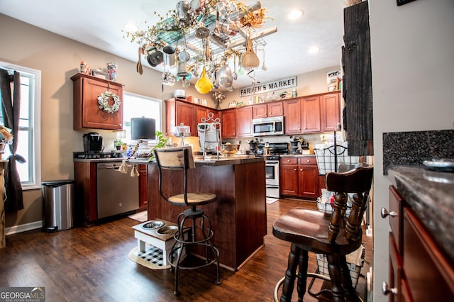 kitchen featuring a kitchen breakfast bar, a kitchen island, dark hardwood / wood-style flooring, and stainless steel appliances