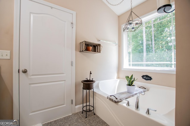 bathroom with vaulted ceiling and a bathing tub