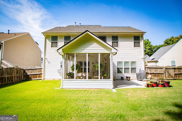 rear view of property with a lawn, a patio area, and a sunroom