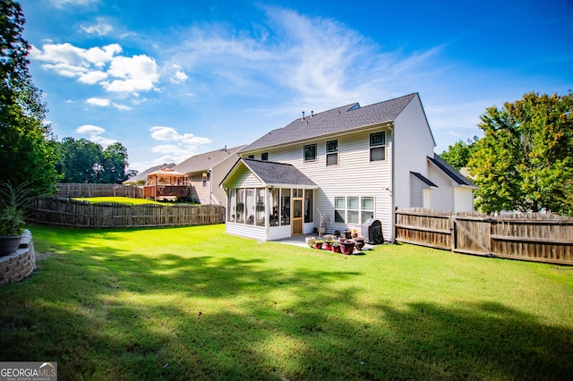 back of property featuring a sunroom, a yard, and a patio