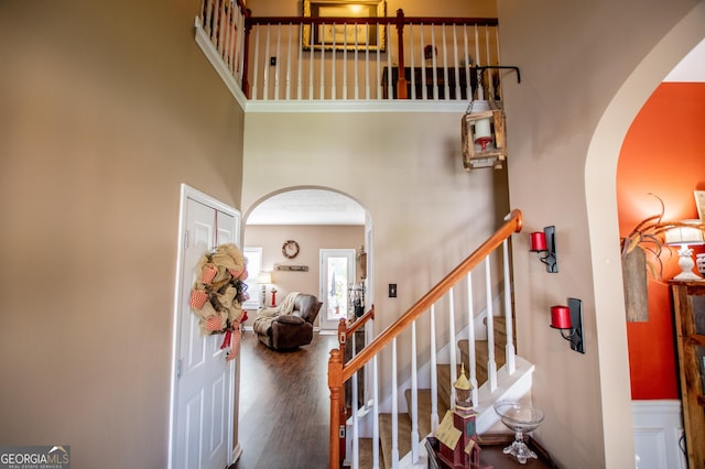 stairs with a high ceiling and hardwood / wood-style flooring