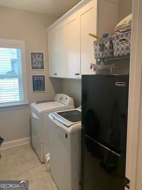 clothes washing area with cabinets, washing machine and dryer, and a wealth of natural light