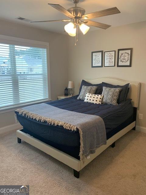 bedroom with ceiling fan and light carpet