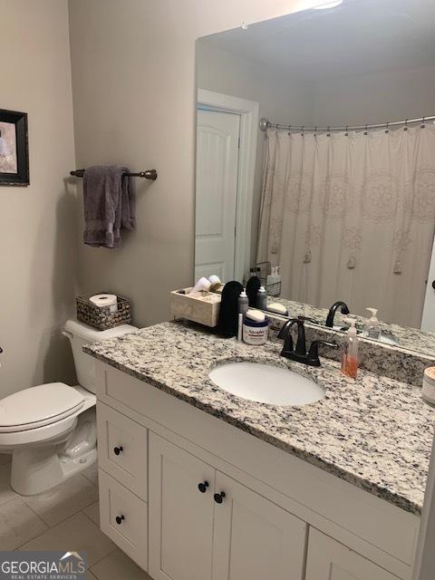 bathroom featuring tile patterned floors, vanity, and toilet