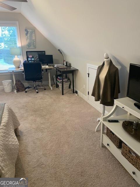 carpeted office space featuring lofted ceiling