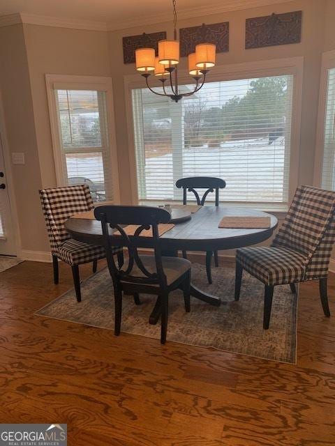 dining area with a notable chandelier, plenty of natural light, wood-type flooring, and ornamental molding