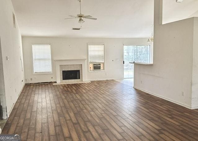 unfurnished living room featuring dark hardwood / wood-style flooring, ceiling fan, a fireplace, and cooling unit