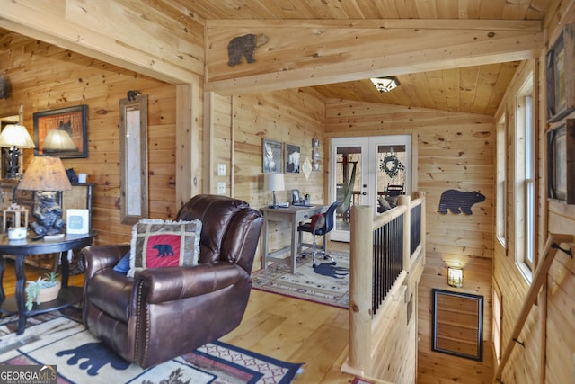 living room featuring hardwood / wood-style floors, french doors, lofted ceiling, and wood walls