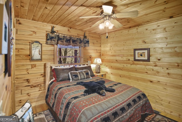 bedroom with ceiling fan, wooden walls, and wooden ceiling