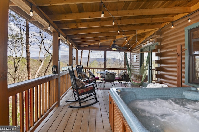 wooden deck featuring a mountain view and a hot tub