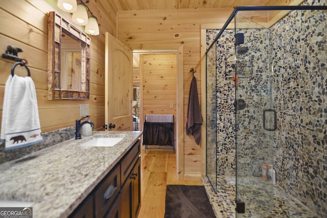 bathroom featuring walk in shower, wood walls, wood-type flooring, vanity, and wood ceiling