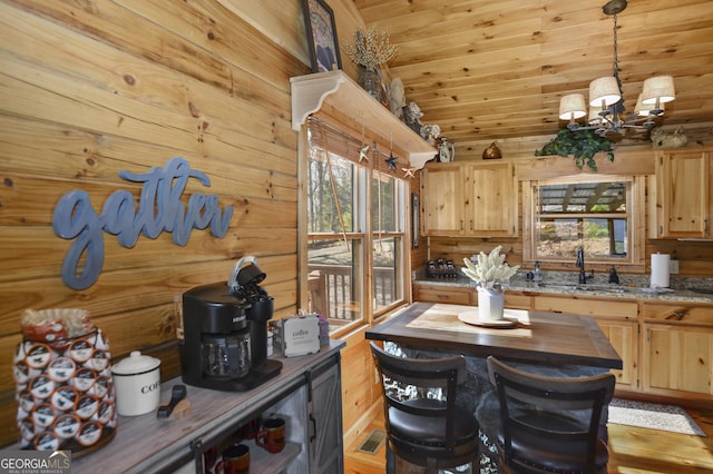 kitchen featuring light brown cabinets, sink, hanging light fixtures, wooden counters, and a notable chandelier