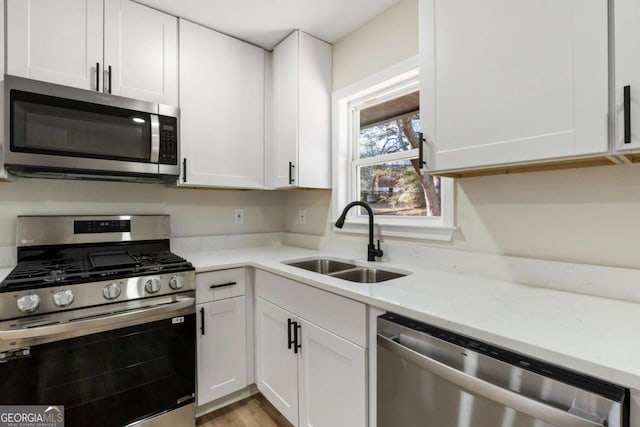 kitchen with sink, white cabinets, and appliances with stainless steel finishes