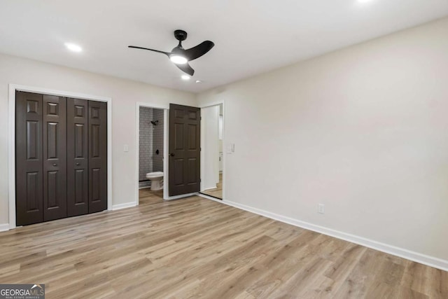 unfurnished bedroom with light wood-type flooring, ensuite bathroom, and ceiling fan