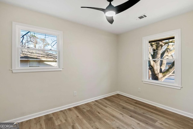 unfurnished room featuring hardwood / wood-style floors, plenty of natural light, and ceiling fan