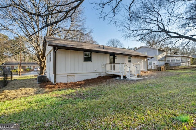 rear view of property with a yard and a deck