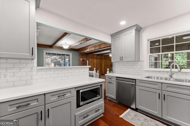 kitchen featuring gray cabinets, sink, beamed ceiling, a healthy amount of sunlight, and stainless steel appliances