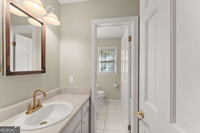 bathroom with toilet, vanity, and tile patterned floors