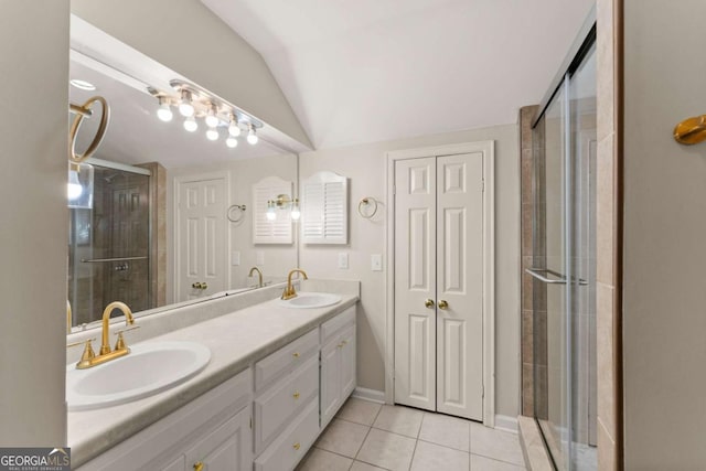 bathroom with lofted ceiling, vanity, tile patterned floors, and a shower with shower door