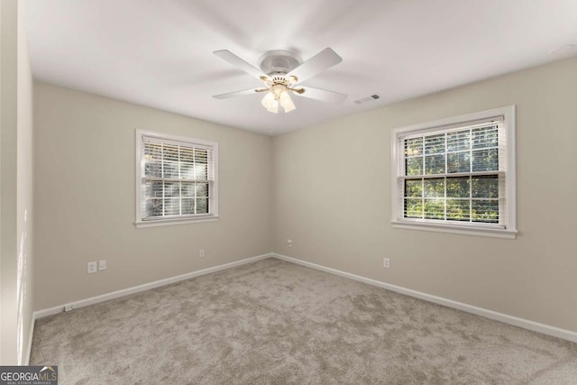 carpeted spare room with ceiling fan