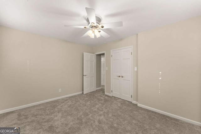 unfurnished bedroom with ceiling fan, light colored carpet, and a closet