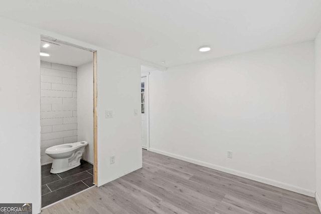 unfurnished bedroom with light hardwood / wood-style floors and ensuite bath