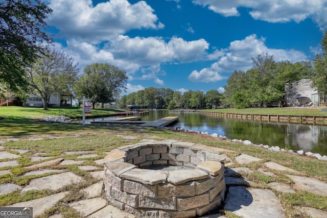 view of patio with a boat dock, a water view, and an outdoor fire pit