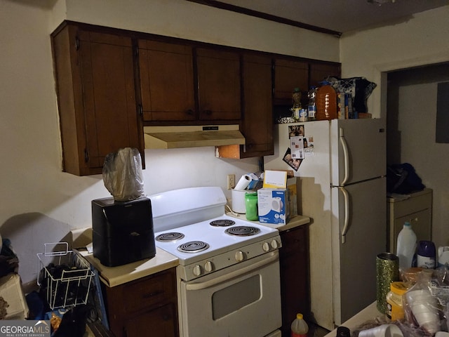 kitchen featuring dark brown cabinetry and white appliances