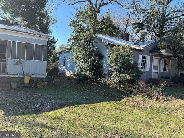 view of property exterior with a sunroom and a yard