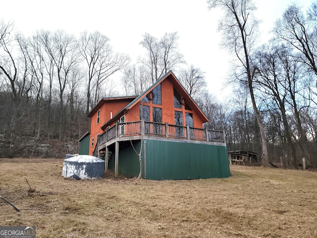 back of house with a deck and a yard