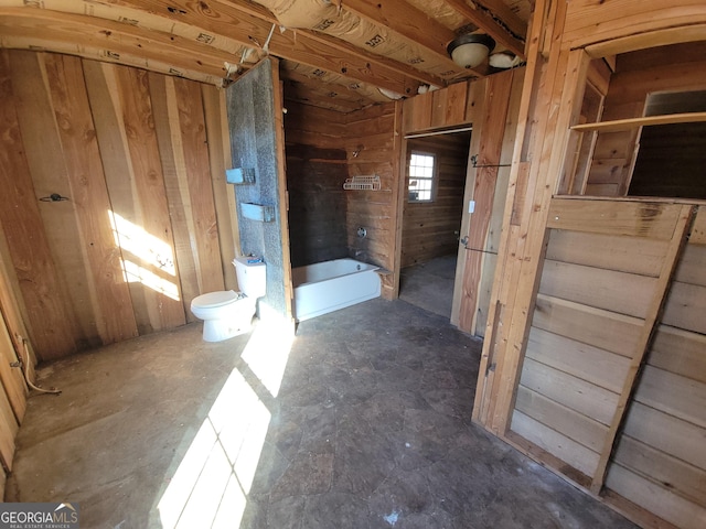 bathroom with toilet and wood walls