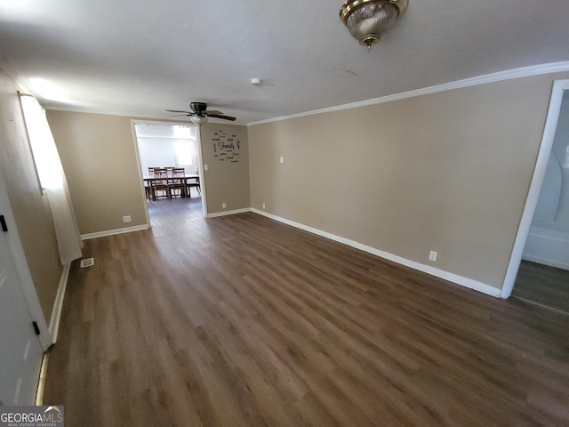 unfurnished living room featuring dark wood-type flooring, ornamental molding, and ceiling fan