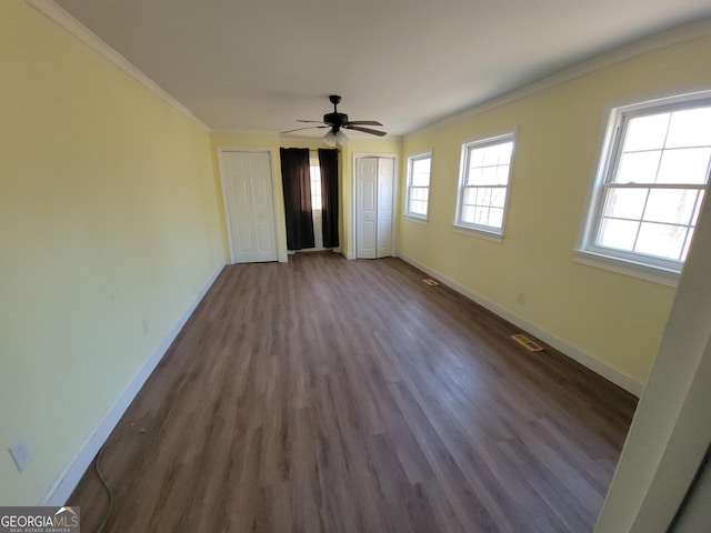 unfurnished bedroom with ceiling fan, dark wood-type flooring, and crown molding