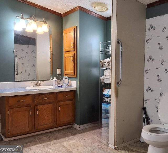 bathroom with vanity, toilet, ornamental molding, a textured ceiling, and walk in shower