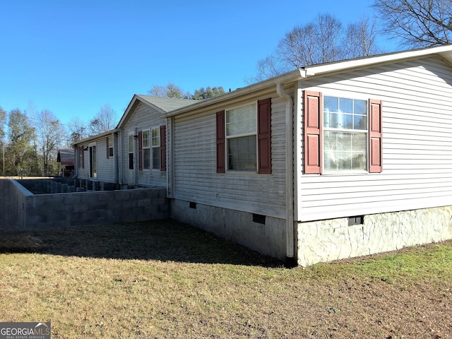 view of side of home with a yard