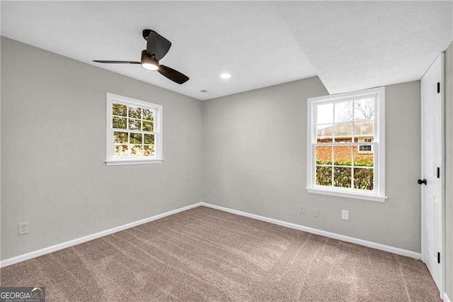 carpeted empty room featuring ceiling fan and plenty of natural light