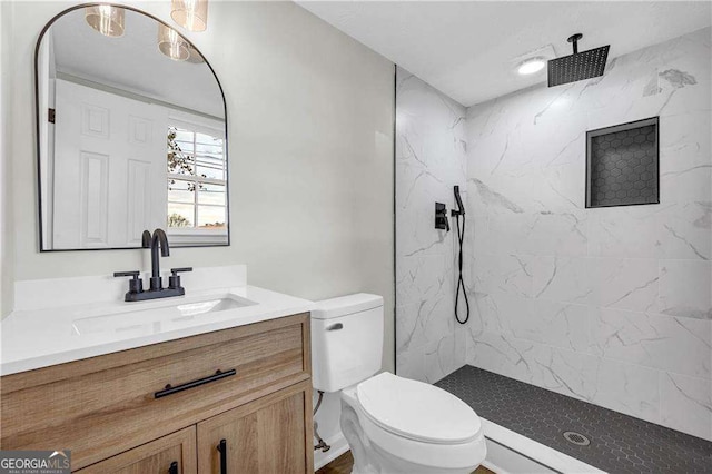 bathroom featuring vanity, toilet, and tiled shower