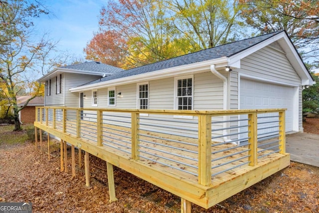 rear view of house featuring a deck and a garage