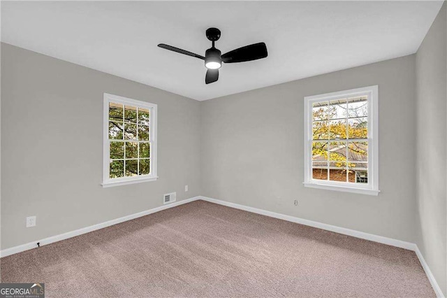 unfurnished room featuring carpet flooring, a wealth of natural light, and ceiling fan